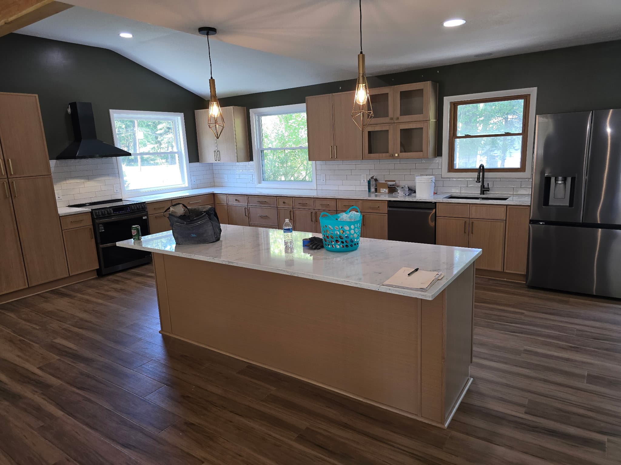 Open-concept kitchen remodel with vaulted ceiling, oak shaker cabinets, and quartz island by 8 Is Enough Construction in Lorain County OH