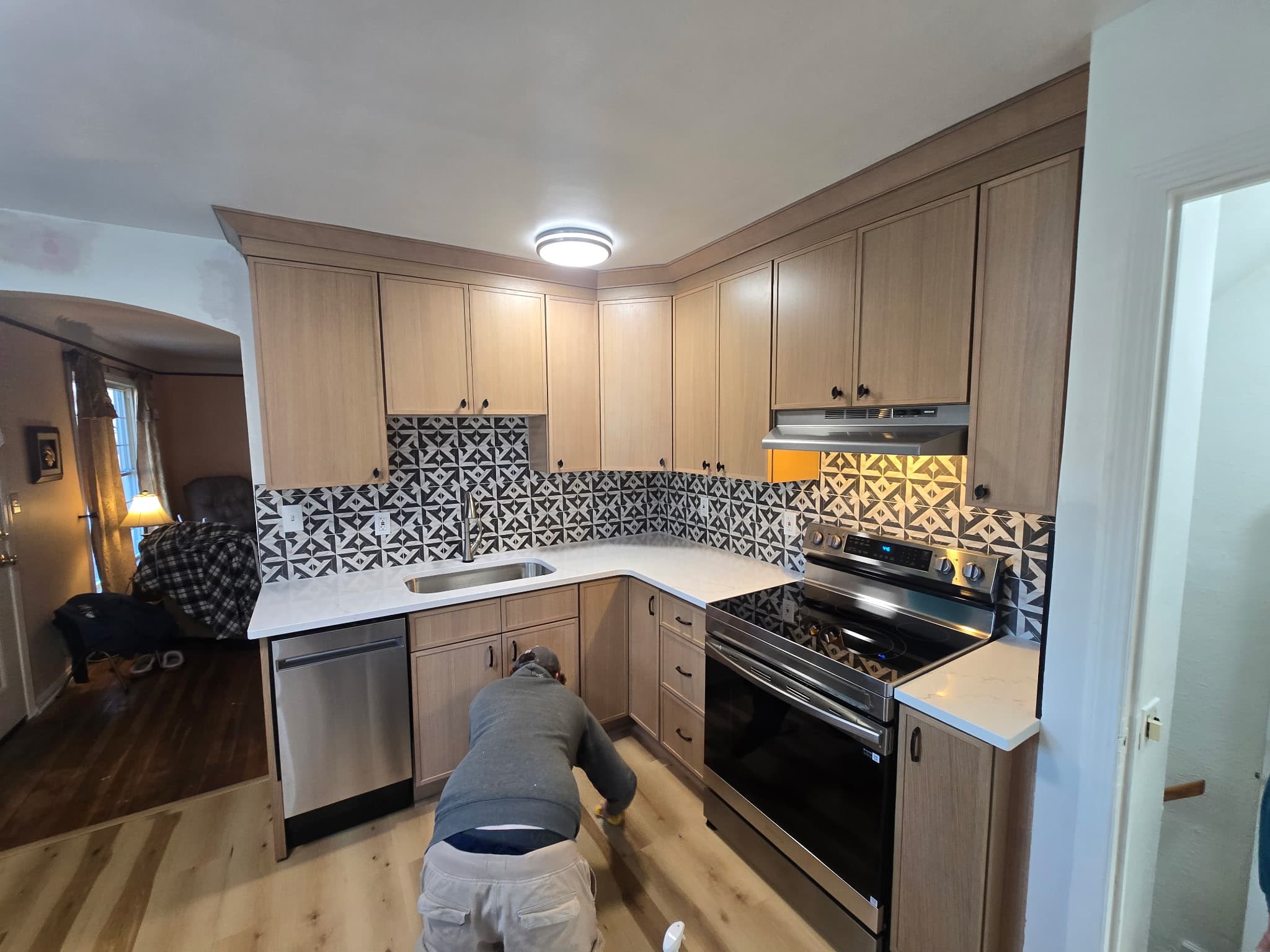 8 Is Enough Construction crew installing hardwood flooring in a kitchen remodel